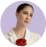Person wearing white suit and red flower brooch.