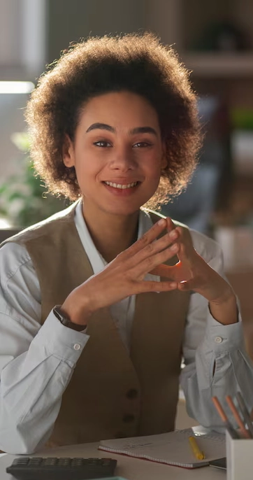 Smiling woman sitting at office desk.