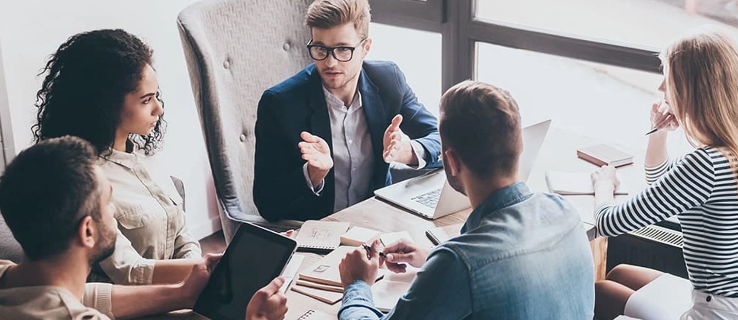 Team discussing project around office table meeting