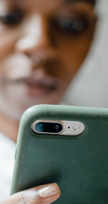 Person using smartphone with green protective case