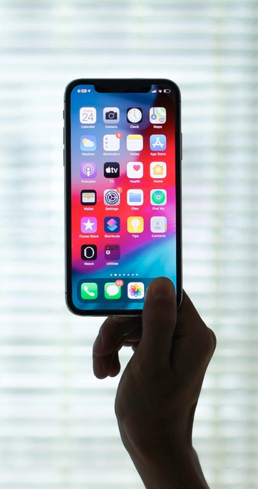 Person holding modern smartphone with apps displayed