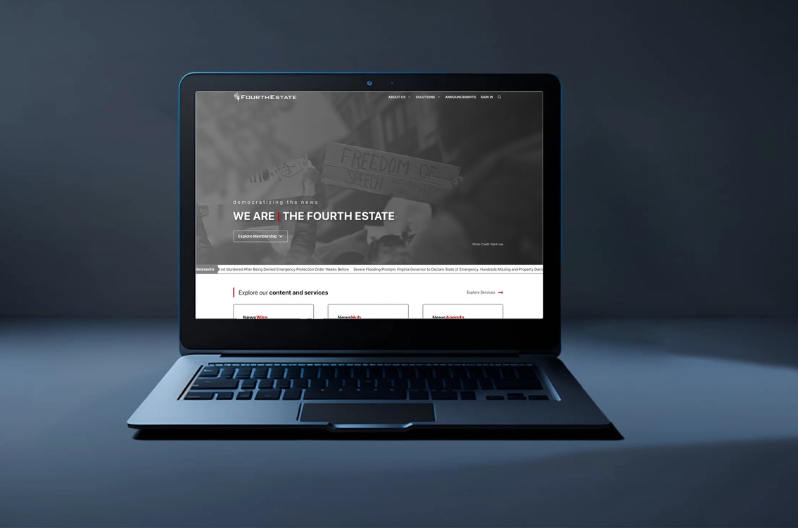 Laptop displaying Fourth Estate website in dim lighting