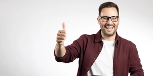Smiling man in glasses giving thumbs up
