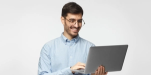 Man smiling while using a laptop computer