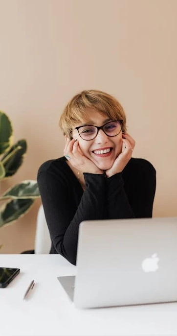 Smiling person working at a laptop desk